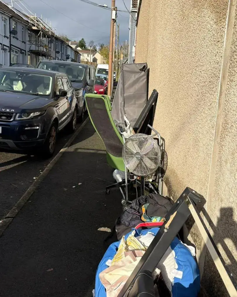 Office chair, fan and bags on a pavement