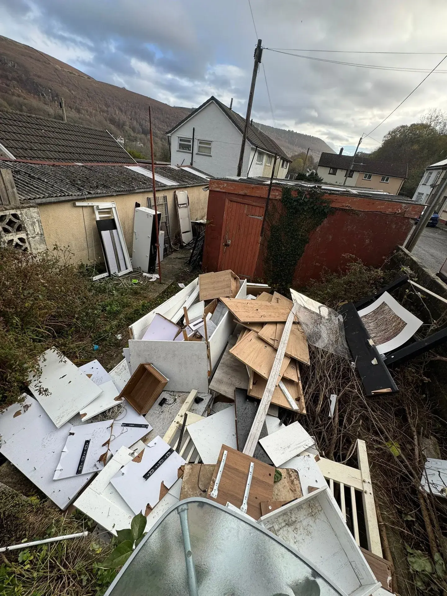 Before: Garden clearance. Broken furniture and rubbish cleared from a valley garden