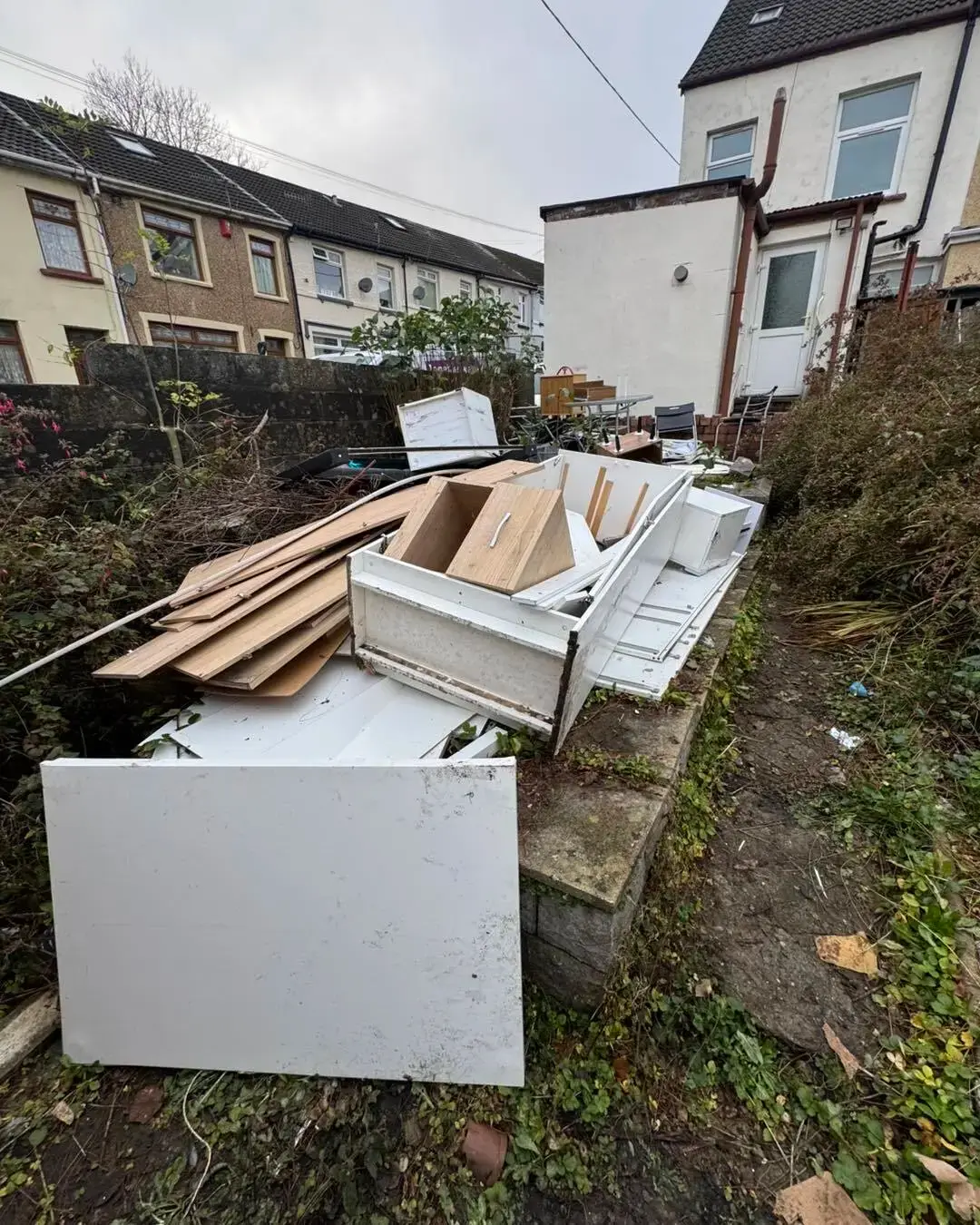 Dismantled wardrobes and drawers in a back garden